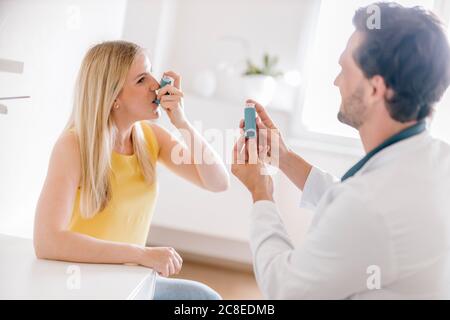 Doctor explaining using of asthma inhaler Stock Photo
