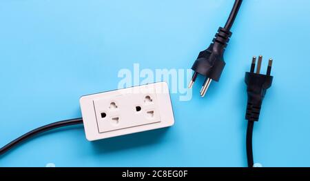 Electrical power strip and plug on blue background. Top view Stock Photo