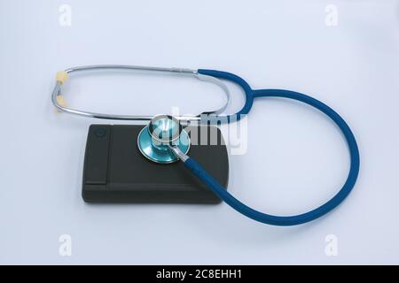 External Computer hard drive and a stethoscope  on a white background. Repair hard drive business concept Stock Photo