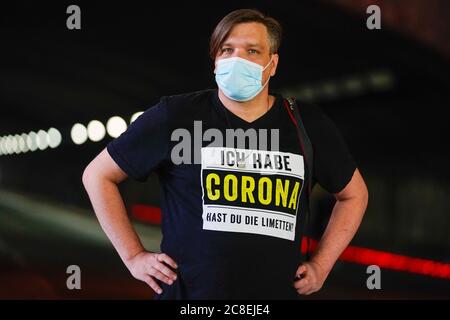 Duisburg, Germany, July 23rd, 2020: Man with a face mask is wearing a t-shirt that says 'I have Corona, do you have limes?'. This does not mean the virus Covid-19, but the Mexican beer brand Corona, which is drunk with lime in the bottle neck. Stock Photo