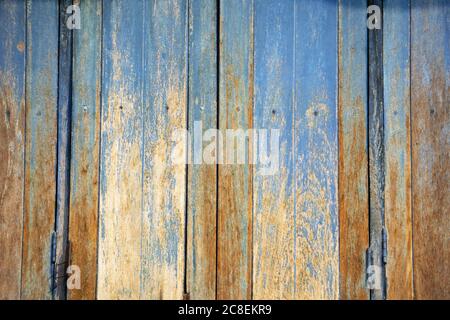 Weathered wood texture background with faded blue paint and abstract patterns from a timber house in Thailand. Stock Photo