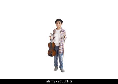 A portrait of a cute Asian elementary school student wearing a jeans and wearing a plaid shirt holding a violin. An isolated image with white backgrou Stock Photo