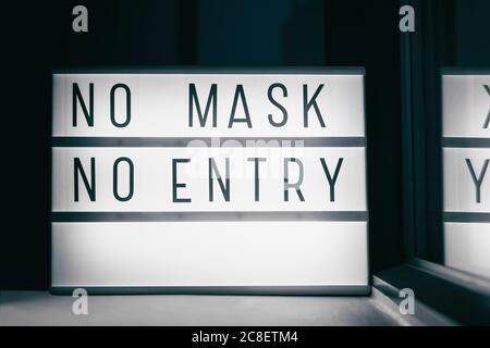 Covid-19 mask obligatory to enter stores . SIGN NO MASK NO ENTRY at storefront window. Face covering wearing mandatory when shopping outside of home Stock Photo