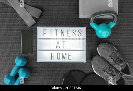 Fitness at home strength training program with dumbbells weights, resistance bands for cross fit workout on exercise mat .Top view of lightbox sign