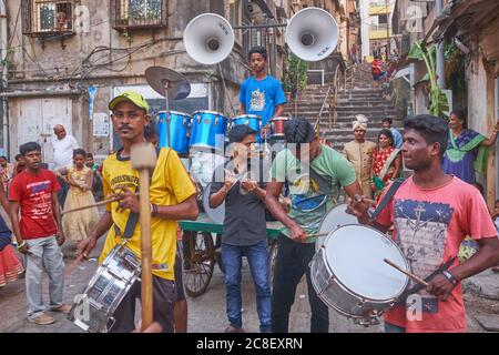 In a backyard in Mumbai, India, a wedding band is playing for a newly-wed couple (background right) in an unusually low-key, low-expense Hindu wedding Stock Photo