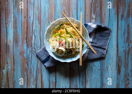 Noodles in a bowl with chopsticks on a background Stock Photo