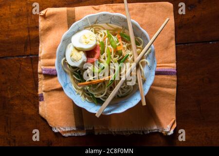 Top view of noodles in a bowl along with chopsticks Stock Photo