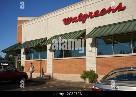 A shopper puts on a face mask before entering the Walgreens pharmacy store in Lake Oswego, Oregon, on Thursday, July 22, 2020, during a pandemic summer. Stock Photo
