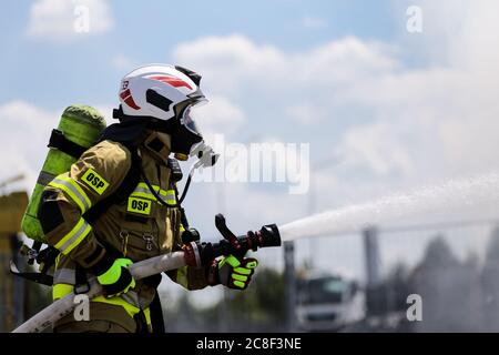 a firefighter in heavy equipment seen while putting out the fire.  The Volunteer Fire Brigade on the premises of the Man Trucks factory performs exerc Stock Photo