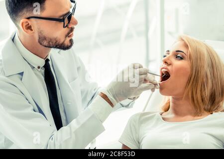 Young dentist examining patient in dental clinic. Stock Photo