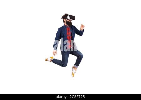 bearded hipster man in virtual reality glasses, jumping and touching invisible buttons, isolated on white background Stock Photo