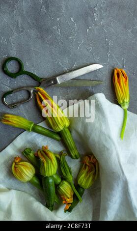 Zucchini flowers and scissors. Flat lay, copy space Stock Photo