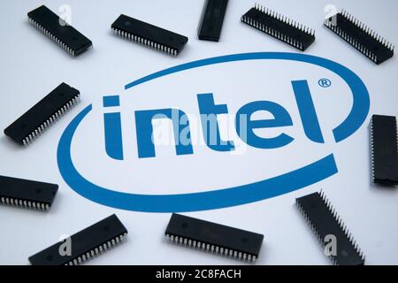Intel company logo seen on the paper and microchips placed around. Selective focus. Stock Photo
