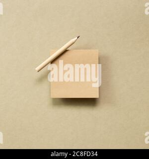 Memo note pad with wooden pencil on brown kraft paper background. top view, copy space Stock Photo