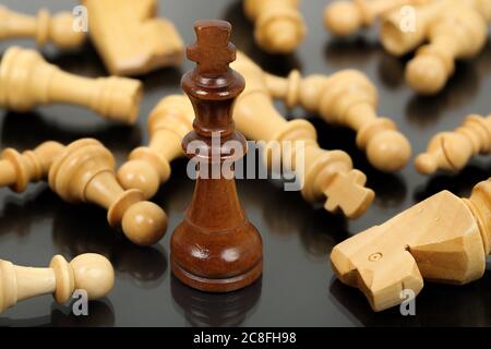 brown chess king surrounded by fallen opponents Stock Photo