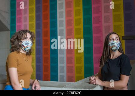 London, UK.  24 July 2020. Tate staff members wearing facemasks pose next to '[no title]', 1979–82, by Jenny Holzer. Press preview ahead of the reopening of Tate Modern on 27 July after the easing of coronavirus pandemic lockdown restrictions by the UK government.  Visitors will need to book timed tickets online and follow one-way routes around the gallery space along with observing social distancing rules. Credit: Stephen Chung / Alamy Live News Stock Photo