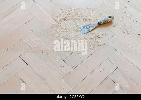 Traditional trowel on a wooden parquet. Repair time Stock Photo