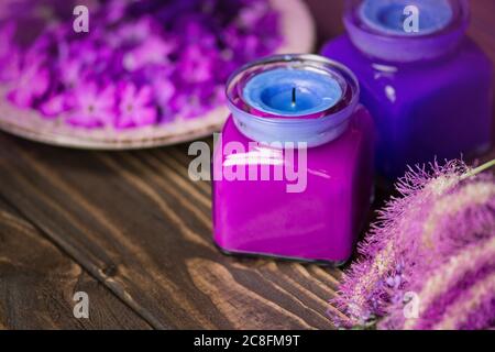 Violet and blue candles on a wooden background Stock Photo