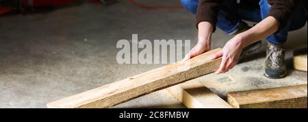 Carpenter builder holding wooden plank at his workstation.  Stock Photo