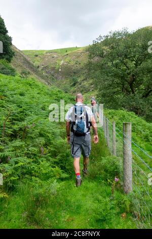 Man walking with family after Covid 19 pandemic lockdown is eased in the hills of Cwm Rheaedr near CilyCwm Carmarthenshire Wales UK  KATHY DEWITT Stock Photo