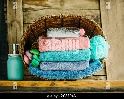 Stack of towels, soap, washcloth, gel. Stack of bath towels on wooden background Stock Photo