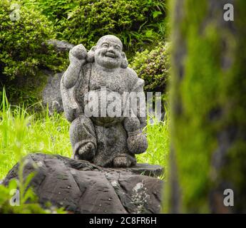 Statue of Budai, a semi-historical Chinese monk from the 10th century who is always depicted as laughing with a protruding pot belly. Stock Photo