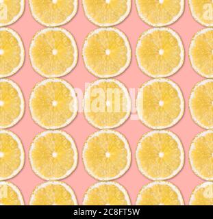 Fresh yellow lemon slices seamless pattern. Close up of citrus fruit slices on pastel pink background. Studio photography. Stock Photo