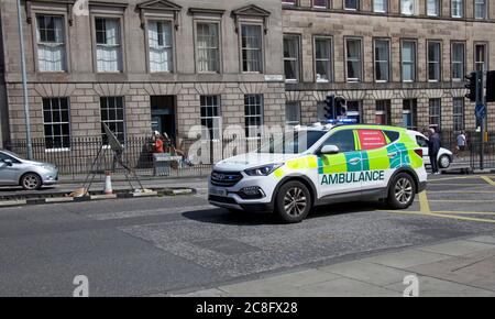 City Centre, Edinburgh Scotland, UK. 24 July 2020. Ambulance emergency vehicle speeds along city street with blue lights flashing Stock Photo