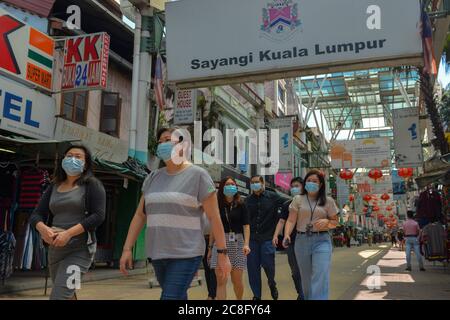 Kuala Lumpur, Malaysia. 24th July, 2020. People wearing face masks walk in Petaling Street in Kuala Lumpur, Malaysia, July 24, 2020. Malaysia reported another 21 new COVID-19 infections, the Health Ministry said on Friday, bringing the national total to 8,861. Credit: Chong Voon Chung/Xinhua/Alamy Live News Stock Photo