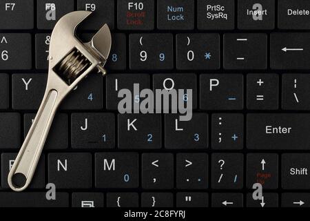 wrench on computer keyboard, computer repair or maintenance concept Stock Photo