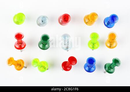 variety of colorful pushpins pinned on white paper Stock Photo
