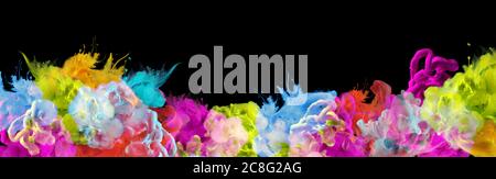 Acrylic blue, green, yellow and red colors in water. Ink blot. Abstract black background. Horizontal long banner. Stock Photo