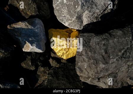 Gold nugget and grey granite stone background Stock Photo