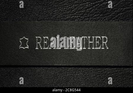 real leather written on black belt on leather surface Stock Photo