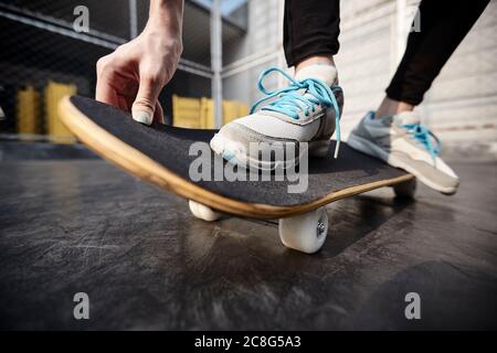 close-up shot of feet of a young asian woman skateboarding outdoors Stock Photo
