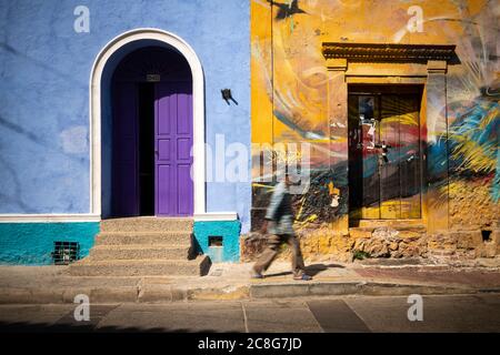 Colourful house fronts, purple door, and painted urals on old house in a terrace in the old city Stock Photo