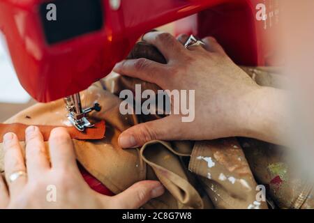 Man using sewing machine in creative studio, close-up Stock Photo