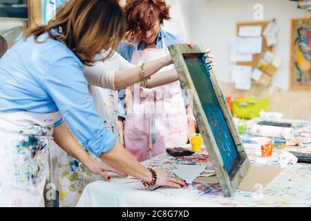 Artist teaching silk screen printing in creative studio Stock Photo