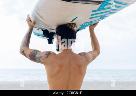Surfer with surfboard by seaside Stock Photo