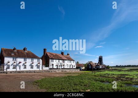 The Royal Oak at Langstone Harbour, Hampshire UK against a blue sky and at low tide with the old mill in the background. Stock Photo