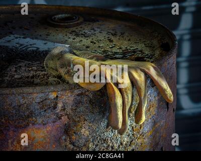 Rotten rubber work glove on top of rusty decaying oil drum in abandoned industrial building, Conshohocken, Pennsylvania, USA Stock Photo