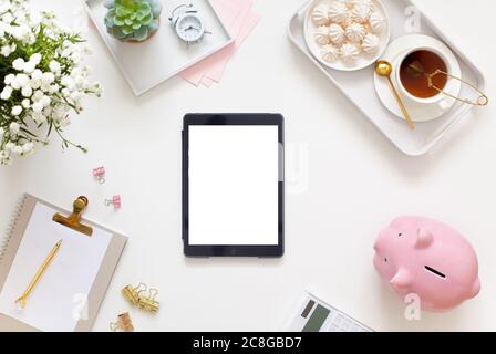 Flat lay, top view office table desk. Workspace with blank clip board, office supplies, pencil, telephone and cup of tea on white background. Stock Photo