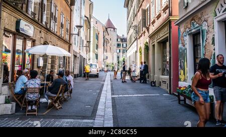 Lausanne Switzerland , 26 June 2020 : Rue de la Tour or Tower street an old pedestrian alley with bars terrace and people and Ale tower in background Stock Photo