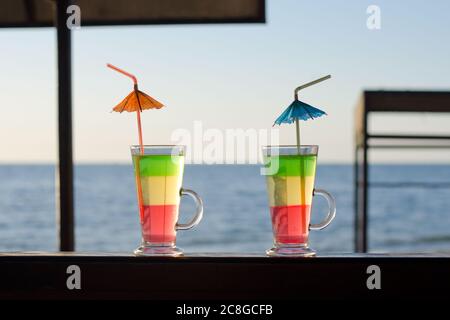 Multi-colored cocktails on wooden reception in the background of the sea Stock Photo