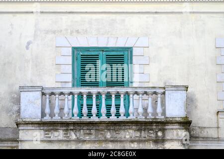 Old green shutters covering a window on a stone balcony of a house in Amalfi, Italy Stock Photo