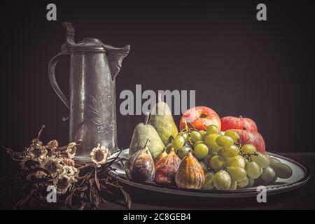 Rustic still life with apples, grapes, pears, and sunflowers. Autumn mood Stock Photo