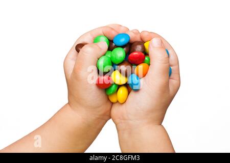 A pile of colorful chocolate coated candy in the children's hands Stock Photo