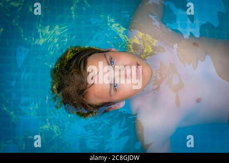 yong man with amazing blue eyes in swimming pool ,enjoying his holiday . top view Stock Photo