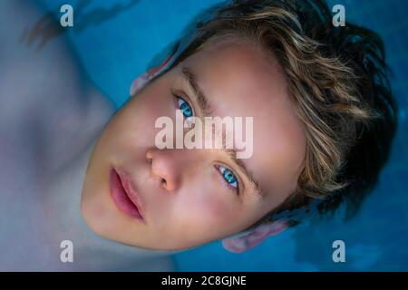 yong man with amazing blue eyes in swimming pool ,enjoying his holiday . top view Stock Photo