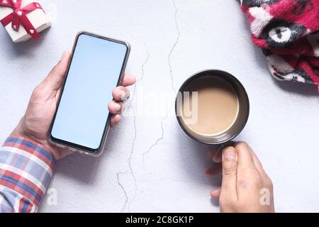 flat composition of hand holding smart phone and coffee on table  Stock Photo